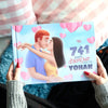 Une femme tenant un livre d’amour personnalisé qui raconte votre histoire – une idée cadeau parfaite pour votre femme ou votre mari, idéale pour un anniversaire.