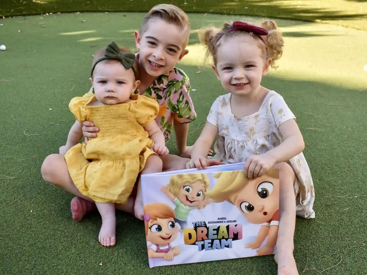 Trois enfants avec la meilleure idée cadeau de l'année : un livre personnalisé pour les enfants Hourra Héros.