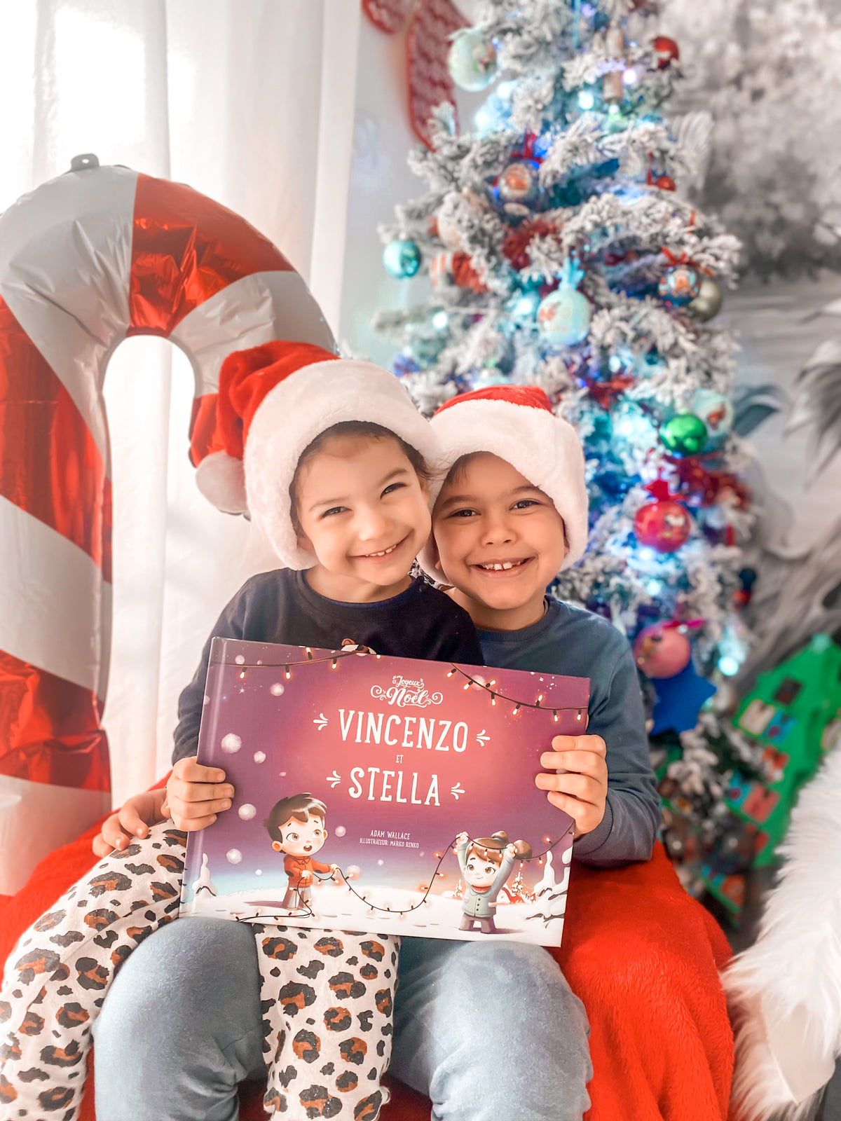 Deux petits tenant dans leurs mains le meilleur cadeau de Noêl pour les enfants : un livre Hourra Héros.