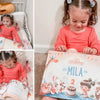 Une petite fille avec son livre d'anniversaire personnalisé qu'elle a reçu pour son deuxième anniversaire.
