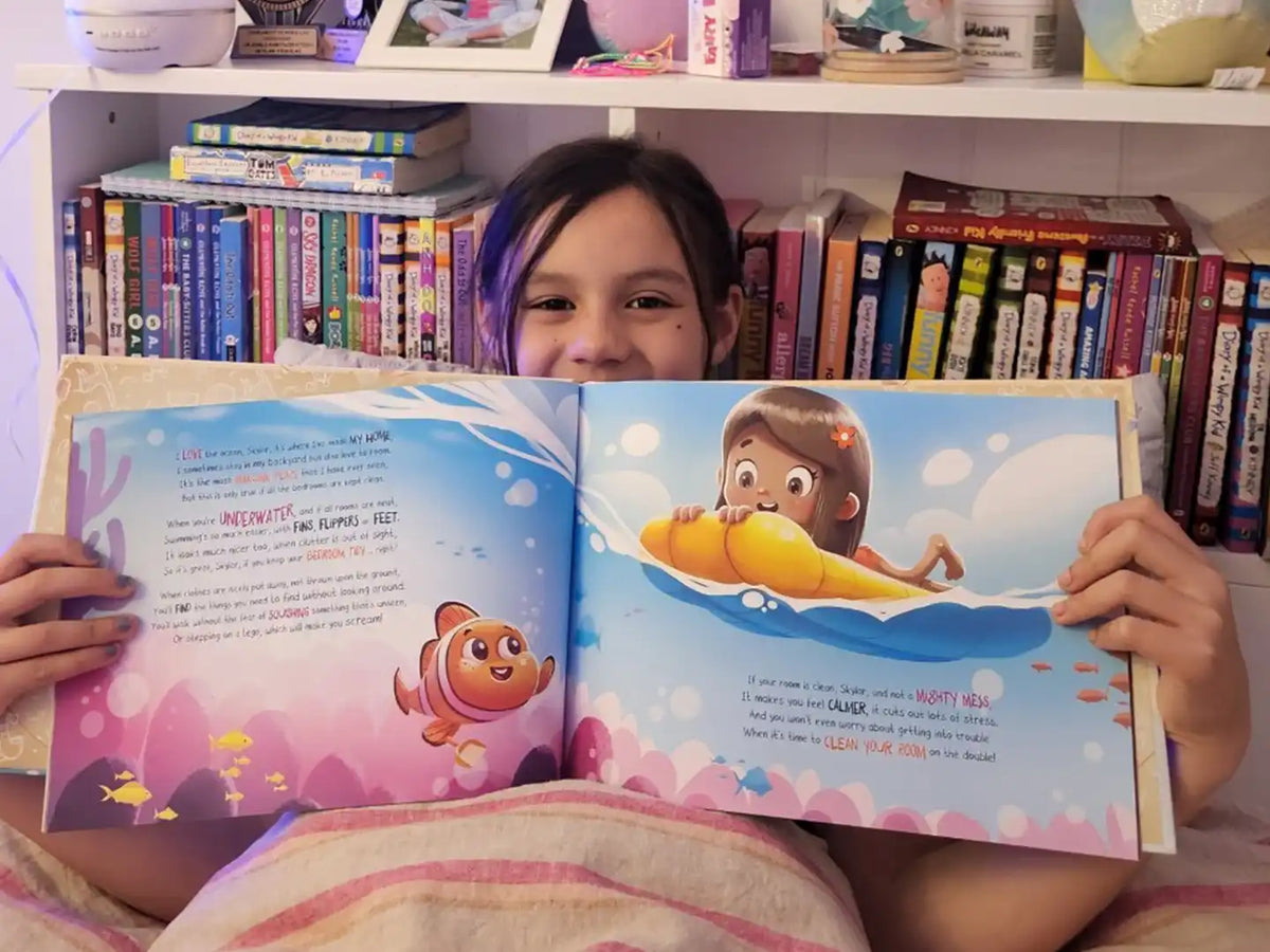 Une fille de huit ans tient son livre d'anniversaire personnalisé.