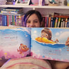 Une fille de neuf ans tient son livre d'anniversaire personnalisé.
