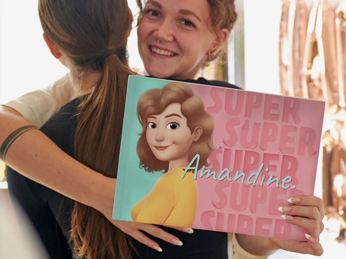Une fille souriante avec son nouveau livre personnalisé qui était un cadeau de son amie.