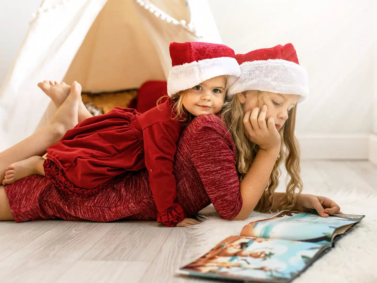 Deux filles lisent un livre spécial Noël personnalisé.