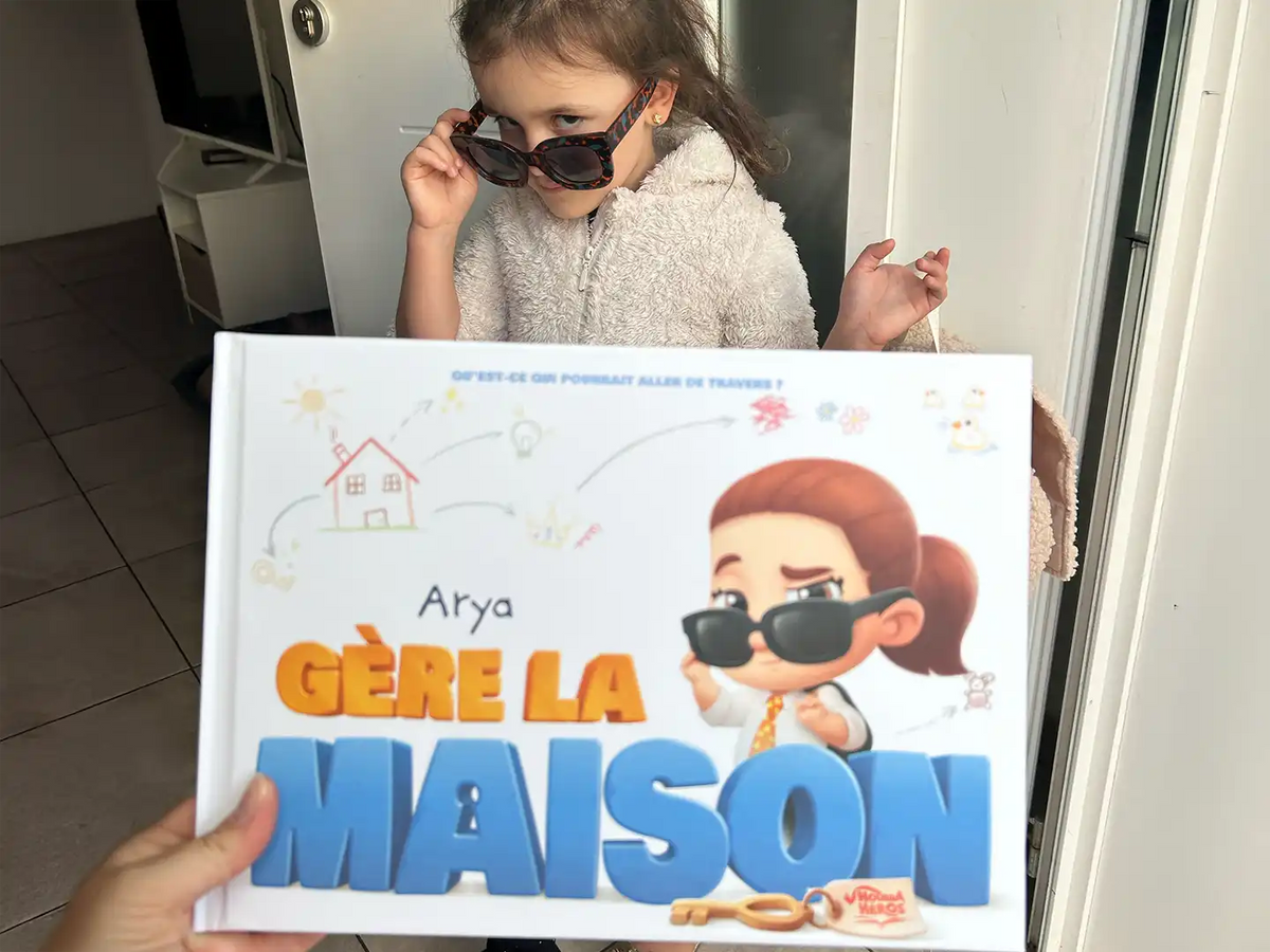 Une fille posant avec son nouveau livre personnalisé sur le fait d'être seule à la maison.