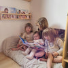 Une fratrie de quatre enfants avec le meilleur cadeau : un livre personnalisé.