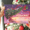 Livre personnalisé “Notre Premier Noël 2025” avec Lola et Maman, tenu devant un sapin de Noël décoré.