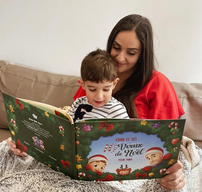 Une maman et son fils lisant leur livre personnalisé de Noël Hourra Héros.