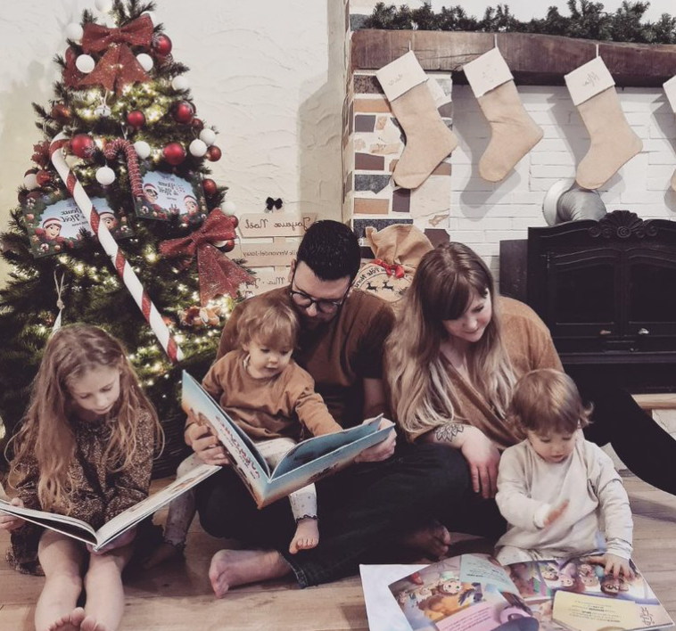 Une famille à Noël lisant des livres personnalisés Hourra Héros, les plus beaux cadeaux !
